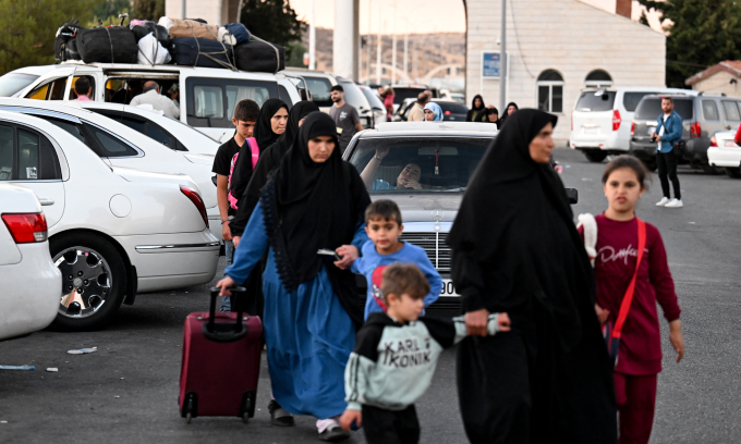 Người tị nạn Lebanon đi qua cửa khẩu để vào lãnh thổ Syria hôm 25/9. Ảnh: AFP