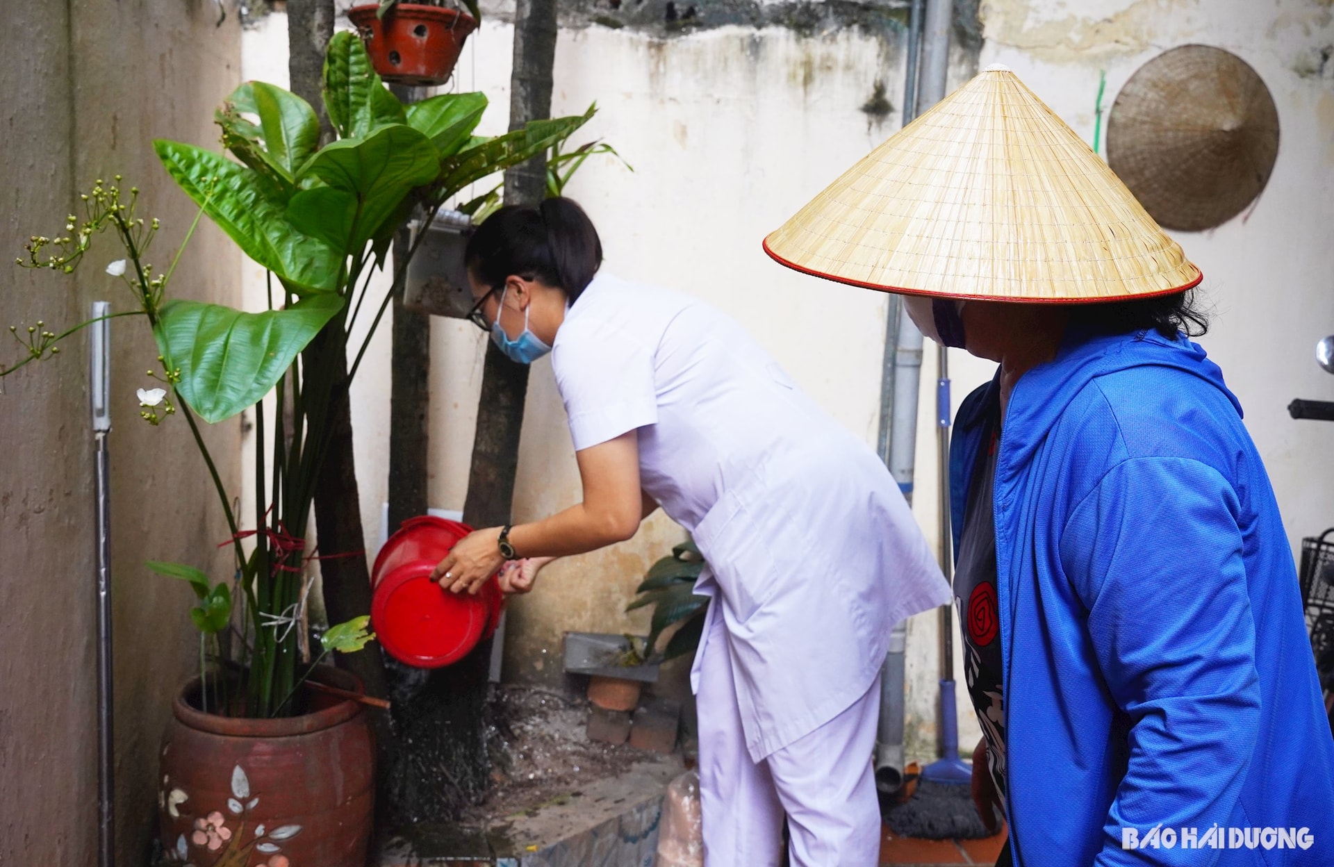 1. Cán bộ Trung tâm y tê TP Hải Dương hướng dẫn nhà dân lật úp vật dụng chứa nước mưa lâu ngày và diệt lăng quăng phòng bệnh sốt xuất huyết