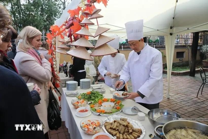 Vietnamese Ambassador to Italy Duong Hai Hung invites delegates and guests to enjoy pho” (Vietnamese noodle soup) and “nem” (spring rolls). (Photo: VNA)