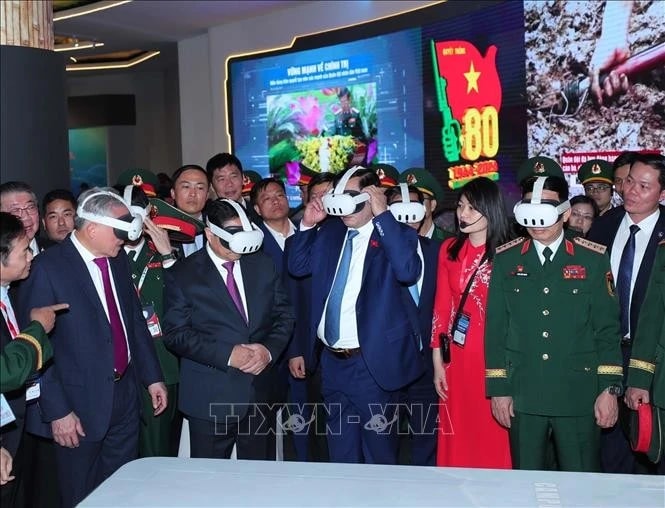 Prime Minister Pham Minh Chinh (second from left) visits the defence product exhibition area of ​​Viettel on December 19. (Photo: VNA)