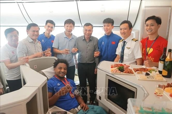 Leaders of the Vietnam Football Federation, coaches and striker Xuan Son and a member of cabin crew pose for a photo. (Photo: VNA)