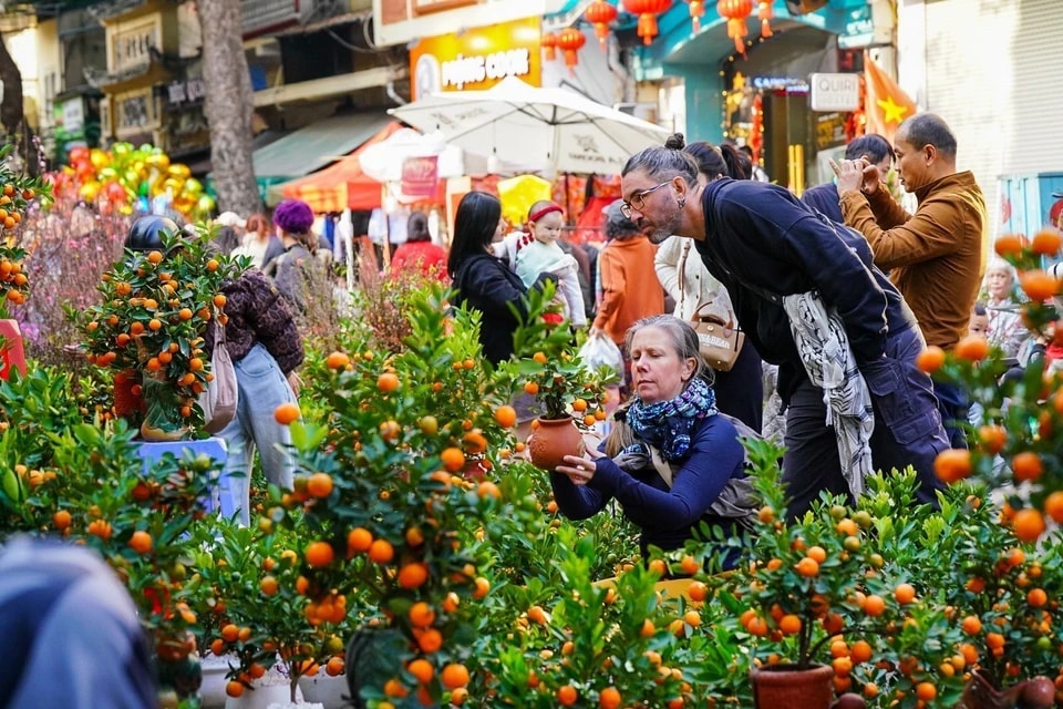 Foreign tourists join in the festive spirit of Tet shopping alongside Vietnamese locals. (Photo: Khanh Hoa – VNA)