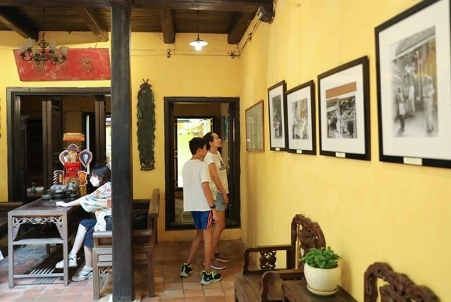 Tourists view photos exhibited in the heritage house on 87 Ma May street, Hanoi. (Photo: VNA) 