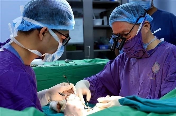 People's Doctor, Professor, and Doctor of Science Nguyen The Hoang, Deputy Director of the 108 Military Central Hospital (right), performs the world’s first hand transplant from a living donor, using the remaining part of an amputated arm that could not be saved (2020). No similar case has been reported globally to date. (Photo: VNA)