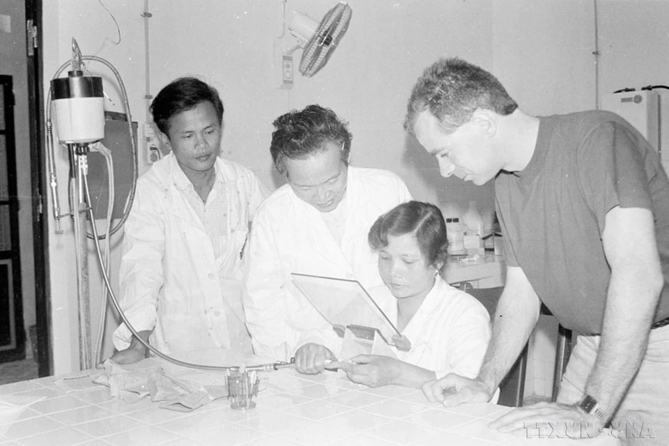 Following national reunification, Vietnam’s healthcare sector made significant progress and achieved important milestones in protecting and caring for public health. In the photo: Experts from the Netherlands’ Committee No. 2 guide staff at National Otorhinolaryngology Institute in making ear molds for hearing aids to support children with hearing impairments (1992). (Photo: VNA)