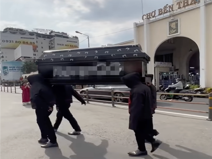 Nhóm thanh niên khiêng quan tài đi qua lại trước chợ Bến Thành. Ảnh:Cắt từ clip