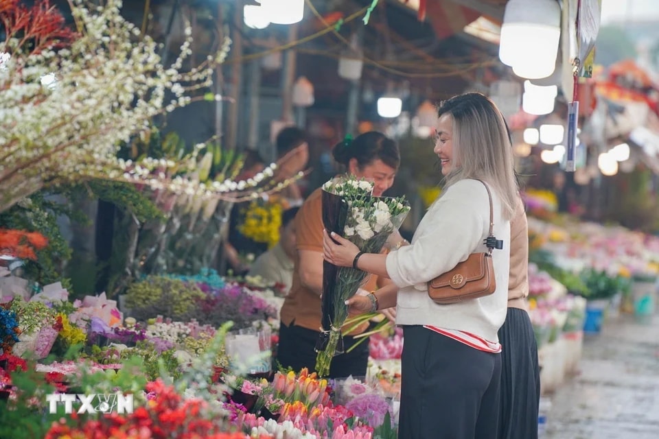Tự chọn cho mình những bông hoa đẹp nhân ngày Quốc tế Phụ nữ 8/3. (Ảnh: Khánh Hòa/TTXVN)