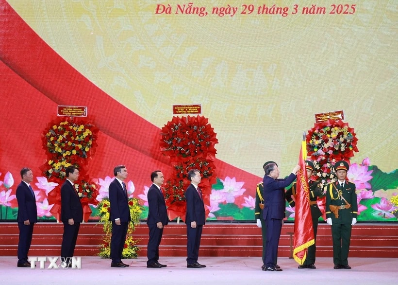 Tổng Bí thư Tô Lâm gắn Huân chương Lao động hạng Nhất lên Cờ truyền thống của Thành phố Đà Nẵng. (Ảnh: Thống Nhất/TTXVN)