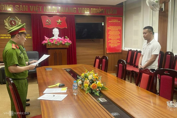 Công an đọc quyết định khởi tố Quang Linh Vlog. Ảnh: Linh Đan