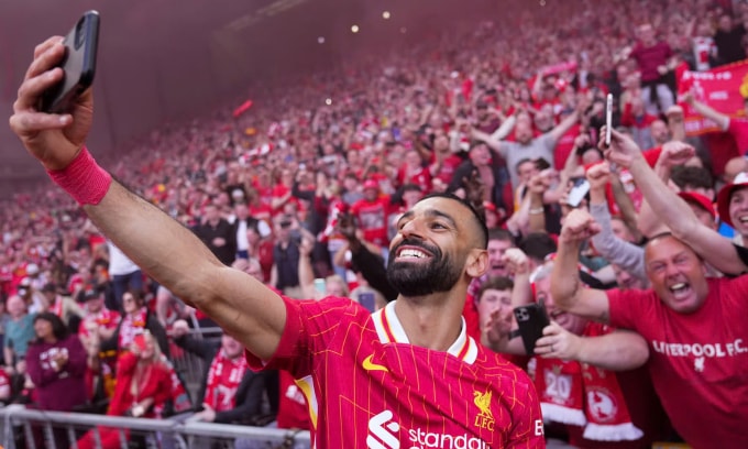 Salah lấy điện thoại của khán giả để selfie sau khi ghi bàn nâng tỷ số lên 4-1 cho Liverpool trước Tottenham, ở vòng 34 Ngoại hạng Anh trên sân Anfield, thành phố Liverpool, Vương quốc Anh ngày 27/4/2025. Ảnh: AP
