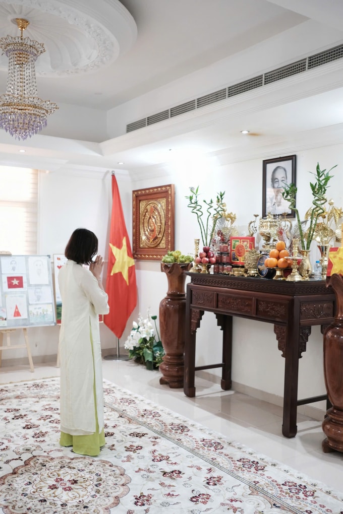 Du khách Việt thắp hương trước bàn thờ Chủ tịch Hồ Chí Minh tại Đại sứ quán Việt Nam ở UAE nhân chuyến du lịch dịp 30/4. Ảnh: Hà Anh