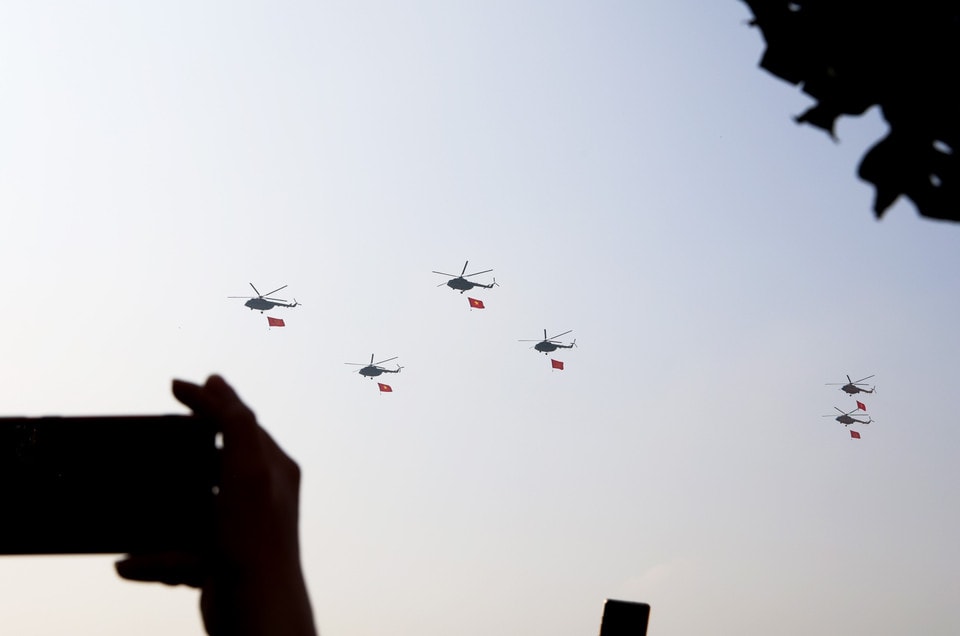 A formation of helicopters carrying the national flag performs in the sky over Ho Chi Minh City. Photo: VNA