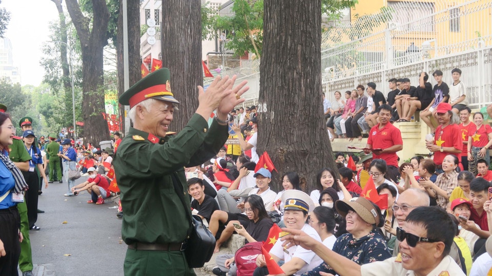 A veteran leads the crowd in singing 