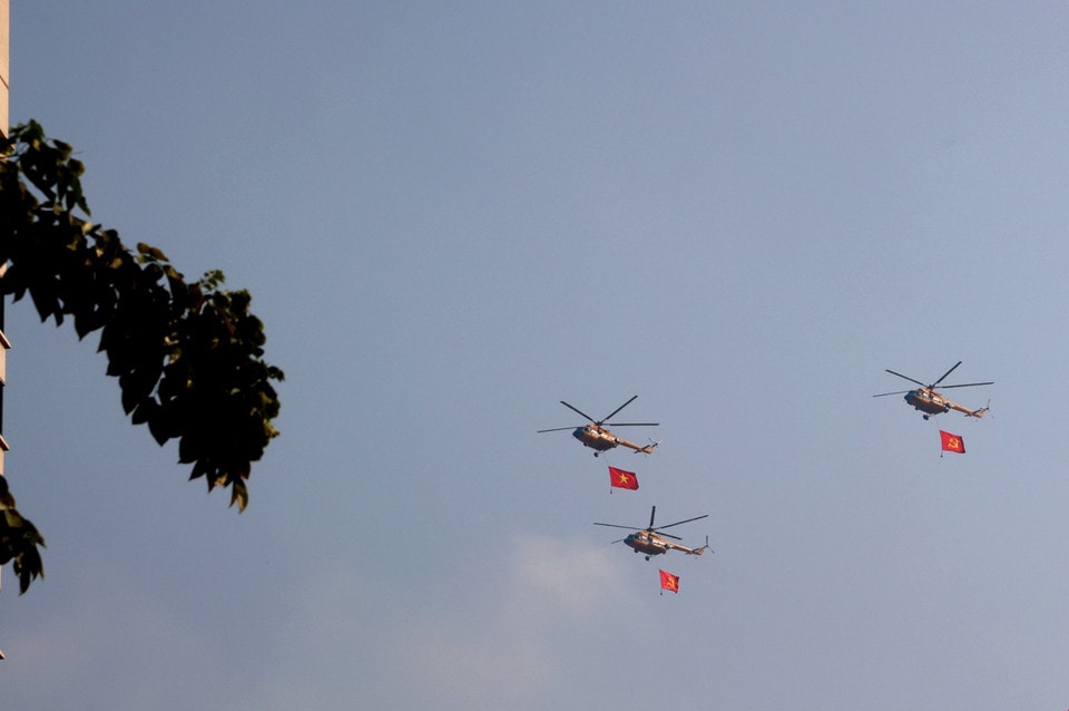 A formation of helicopters carrying the national flag performs in the sky over Ho Chi Minh City. Photo: VNA