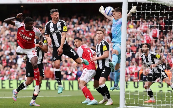 Thủ môn Nick Pope đẩy cú đánh đầu cận thành của Thomas Partey. Ảnh: Reuters