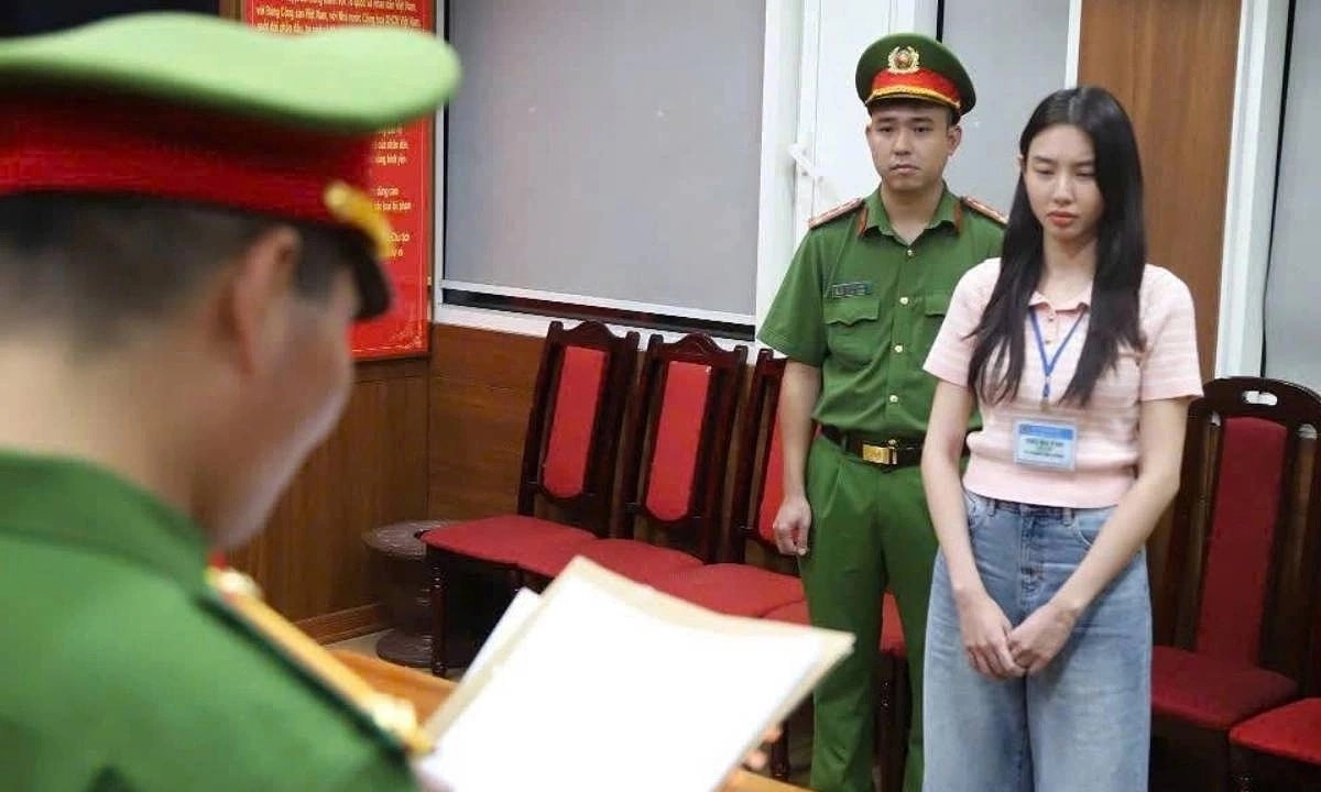Hoa hậu Thùy Tiên (phải) nghe cảnh sát đọc lệnh khởi tố, bắt tạm giam ngày 19/5