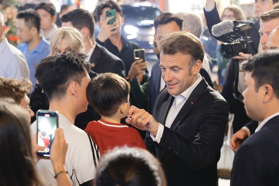 President Macron and his spouse meet with residents while strolling through Hanoi’s Old Quarter. (Photo: VNA)
