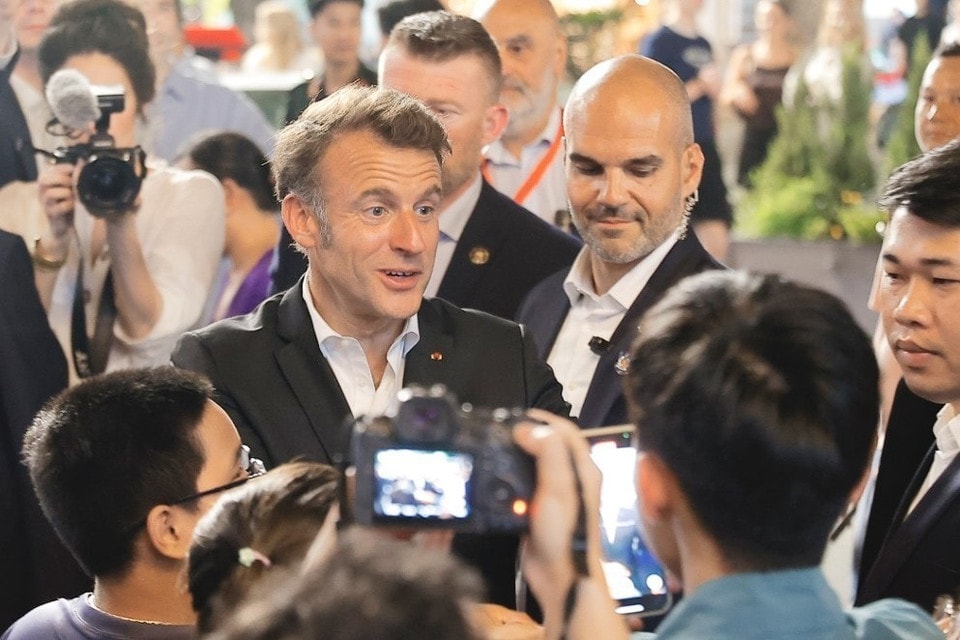 French President Macron talks with locals (Photo: VNA)