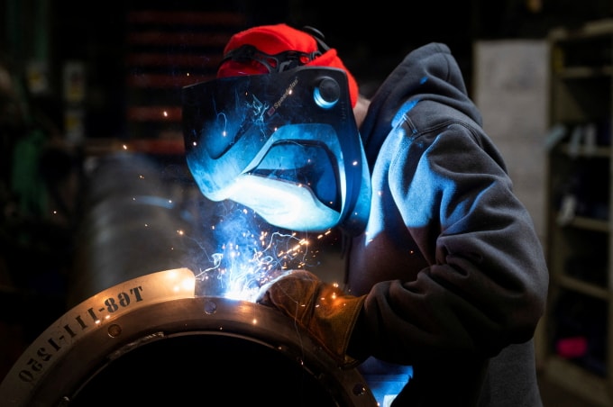 Một công nhân đang hàn ống thép chế tạo bộ phận máy gặt đập liên hợp tại nhà máy ở Mendota, Illinois, Mỹ ngày 21/2. Ảnh: Reuters