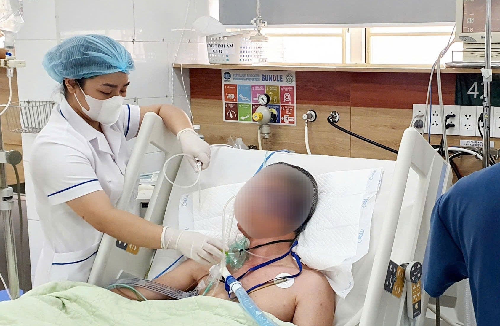 Bệnh nhân thoát khỏi hôn mê, vẫn phải hỗ trợ hô hấp, lọc máu do ngộ độc cồn giả chứa methanol. (Ảnh: Nguyên Hà)