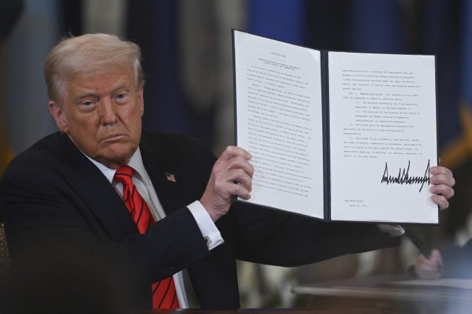 Tổng thống Mỹ Donald Trump giơ sắc lệnh hành pháp giải thể Bộ Giáo dục trong lễ ký tại Phòng Đông, Nhà Trắng, ngày 20/3. Ảnh: AFP