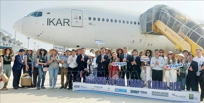 Russian tourists pose for a photo after landing at Cam Ranh International Airport, Khanh Hoa province, on April 18, 2025. (Photo: VNA)