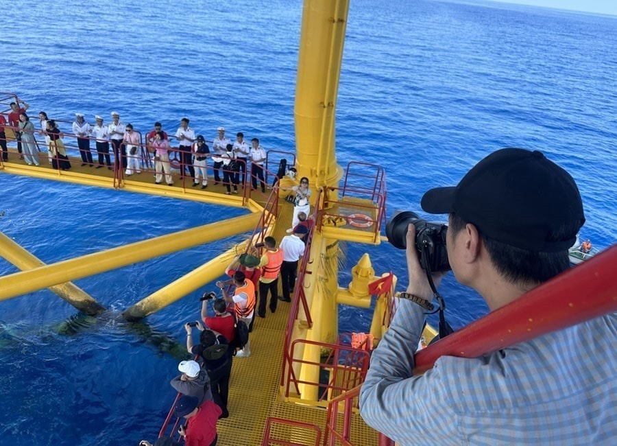 Reporters record the exchange between a working group and soldiers on the DK1 Phuc Tan Platform (2023). (Photo: VNA)