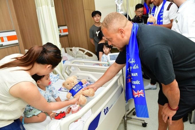 Cựu hậu vệ Wes Brown tặng quà cho một bệnh nhân nhỏ tuổi. Ảnh: Thanh Tùng