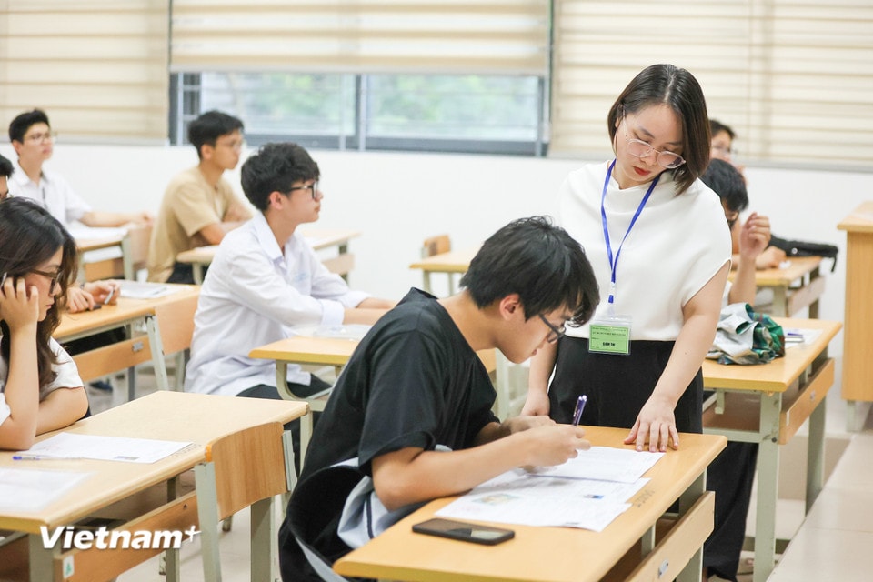 Cán bộ coi thi hướng dẫn thí sinh kiểm tra lại thông tin trong buổi làm thủ tục dự thi.