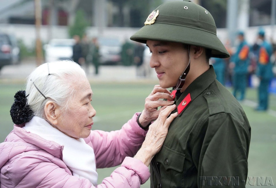 Nguyen Thi Minh Thuan, 90, bids farewell to her grandson as he departs for public security service in Dong Da district, Hanoi (February 2025). (Photo: Pham Kien – VNA)