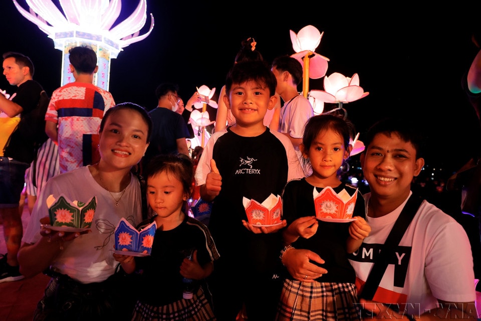 A family releases lanterns together during the 2024 Hue International Arts Festival Week. (Photo: Minh Quyet – VNA)