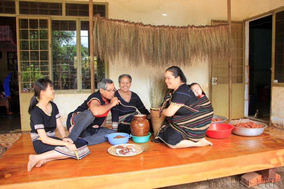 A Central Highlands family gathers to enjoy traditional food and share jars of ruou can (fermented rice wine). (Photo: Hong Diep – VNA)