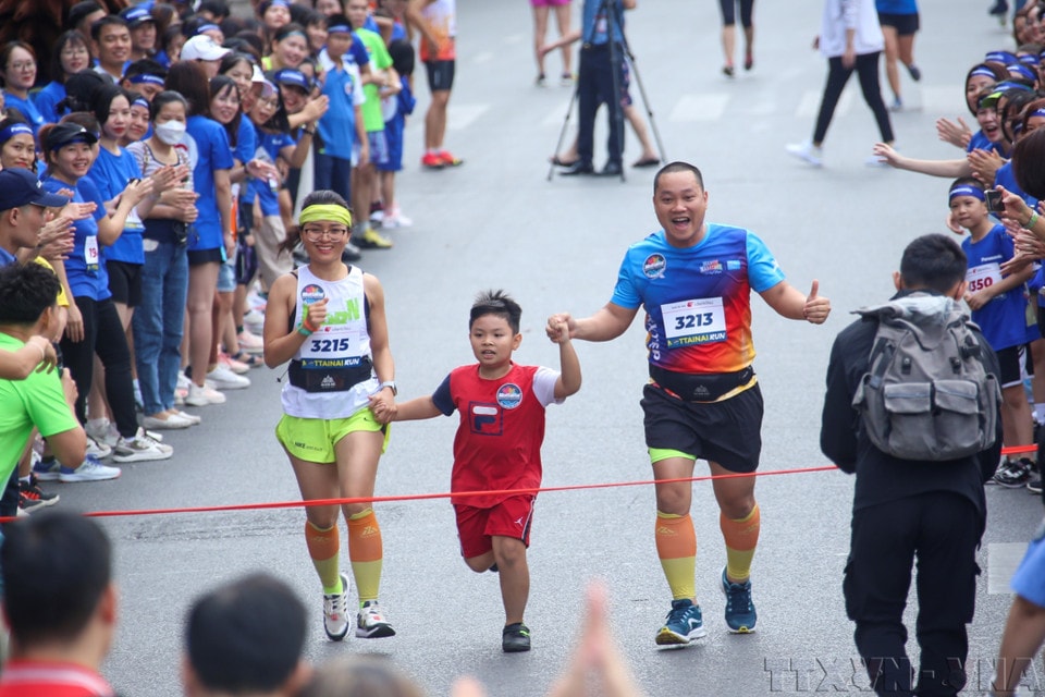 A family takes part in a charity run during the 2023 Mottainai Festival, themed “Give love, receive happiness.” (Photo: Tuan Duc – VNA)