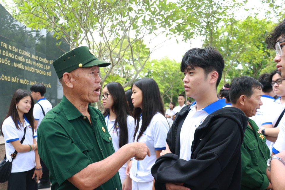 War veterans and former youth volunteers talk with members of the youth and student delegation. (Photo: VNA)