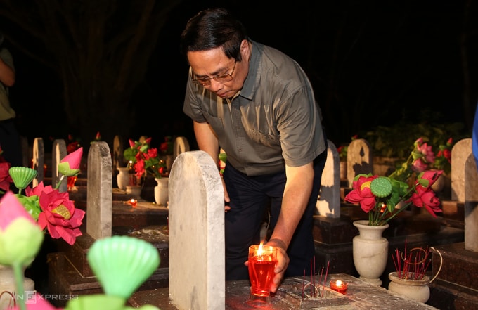 Thủ tướng Phạm Minh Chính thắp nến tại các phần một liệt sĩ Nghĩa trang liệt sĩ quốc gia Trường Sơn. Ảnh: Đắc Thành