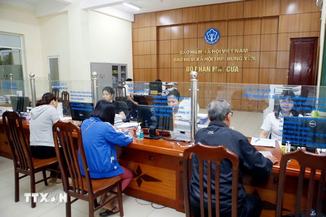 Nhân viên Bảo hiểm Xã hội tỉnh Hưng Yên hướng dẫn người dân làm thủ tục tham gia Bảo hiểm xã hội. (Ảnh: Phạm Kiên/TTXVN) ttxvn-bao-hiem-xa-hoi-5554.jpg