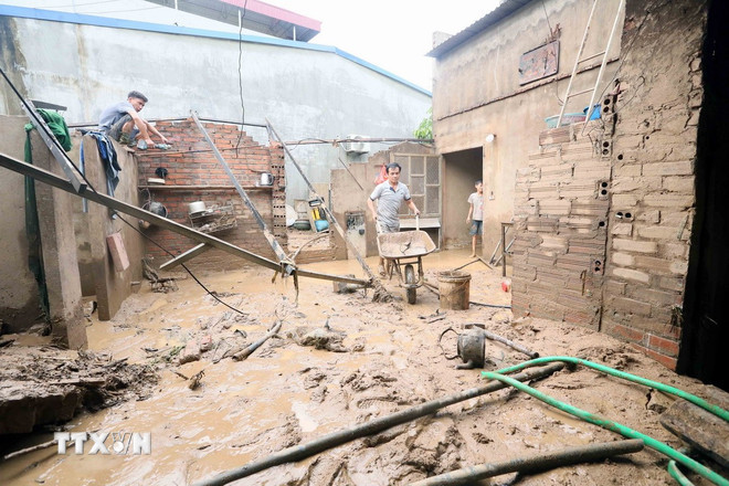 Nhân dân xã Chiềng Sơ (tỉnh Sơn La) khẩn trương san gạt bùn. (Ảnh: Quang Quyết/TTXVN) ttxvn-son-la-resize.jpg