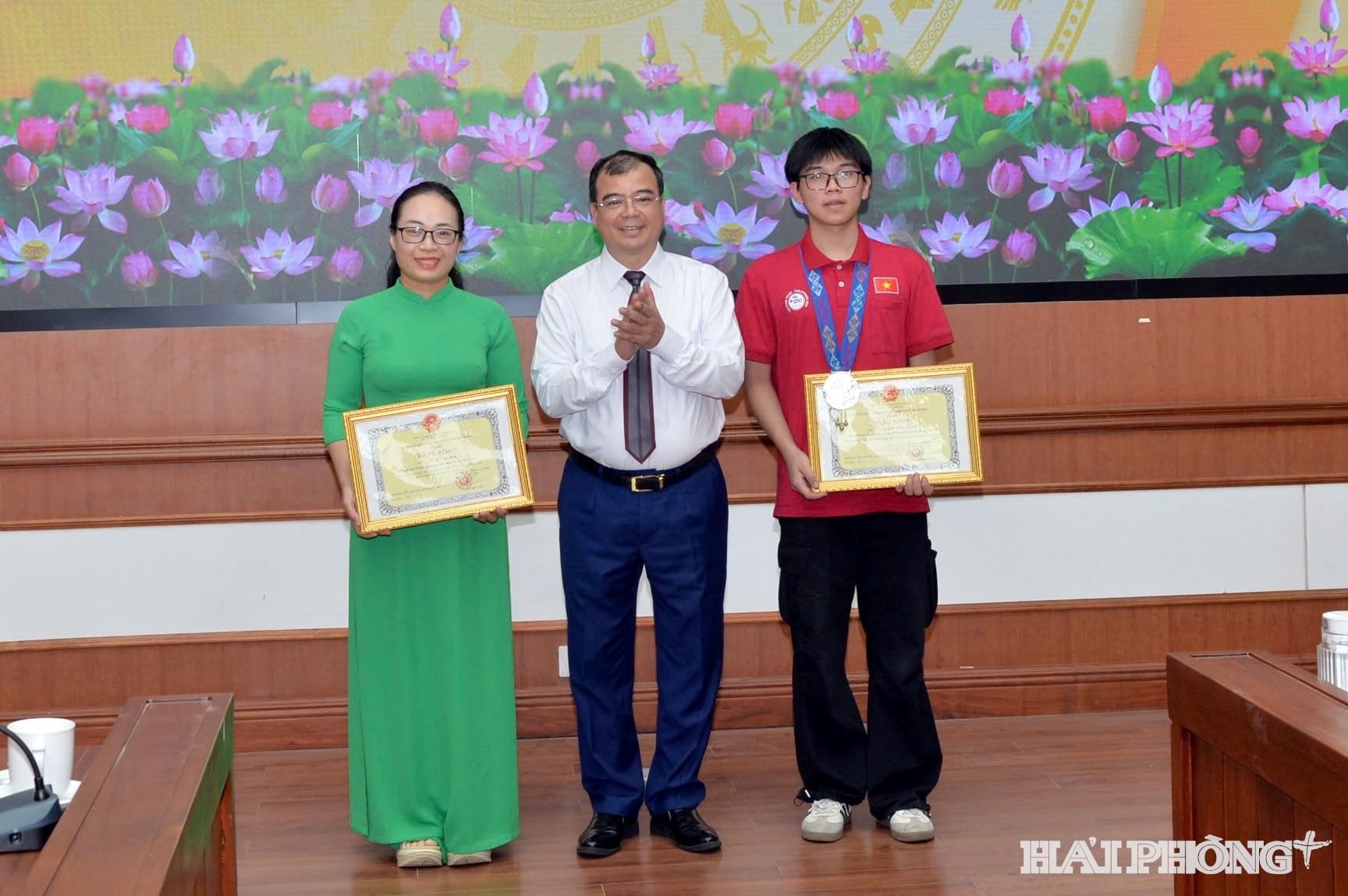 Đồng chí Nguyễn Minh Hùng, Phó Chủ tịch UBND thành phố trao bằng khen của Chủ tịch UBND thành phố cho em Nguyễn Hữu Thành và cô giáo Vũ Thị Thu Huyền