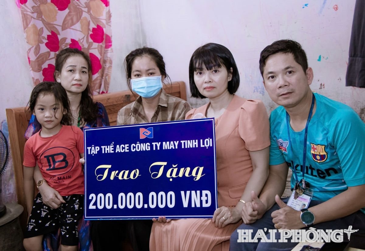 Đại diện tập thể cán bộ, công nhân Công ty TNHH May Tinh Lợi trao tiền hỗ trợ chị Huế