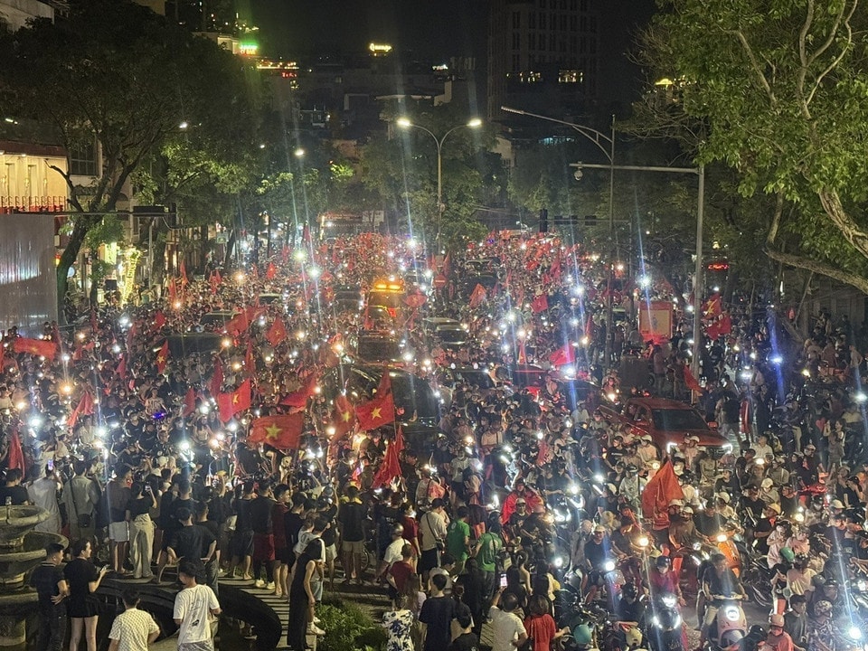 Locals parade with national flags through Hanoi streets. (Photo: VNA)