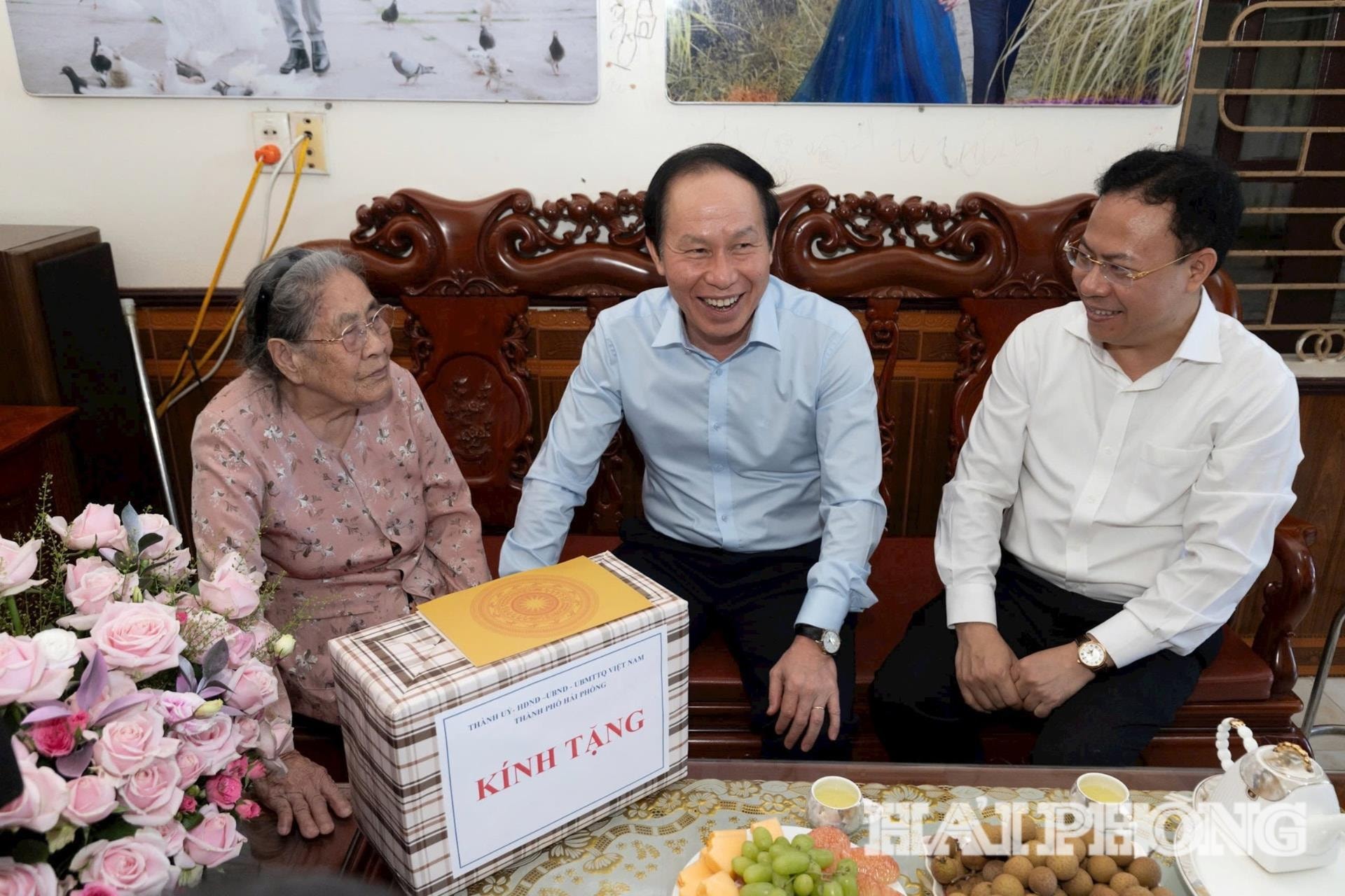 Đồng chí Bí thư Thành uỷ Lê Tiến Châu (ngôigiữa) bày tỏ vui mừng khi mẹ Gái còn minh mẫn, khoẻ mạnh và quan tâm tới các vấn đề thời sự của đất nước, địa phương