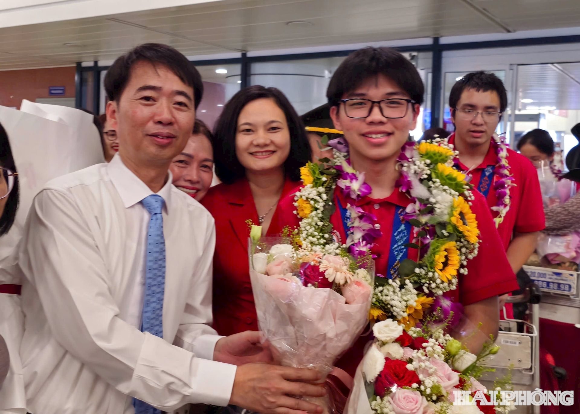 Đồng chí Đỗ Duy Hưng, Phó giám đốc Sở Giáo dục và Đào tạo tặng hoa chúc mừng Hữu Thành khi về đến sân bay