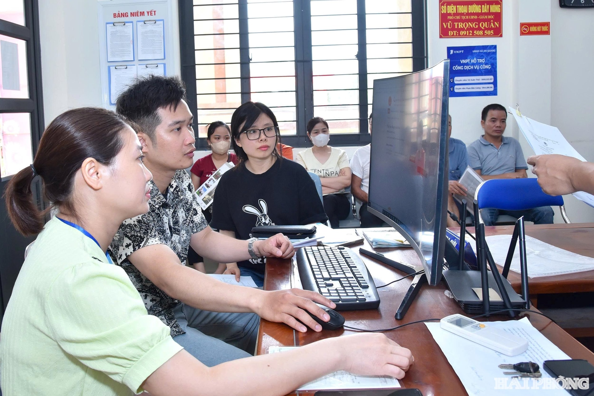 Cán bộ, công chức Trung tâm Phục vụ hành chính công xã An Quang hướng dẫn người dân nộp hồ sơ trực tuyến.