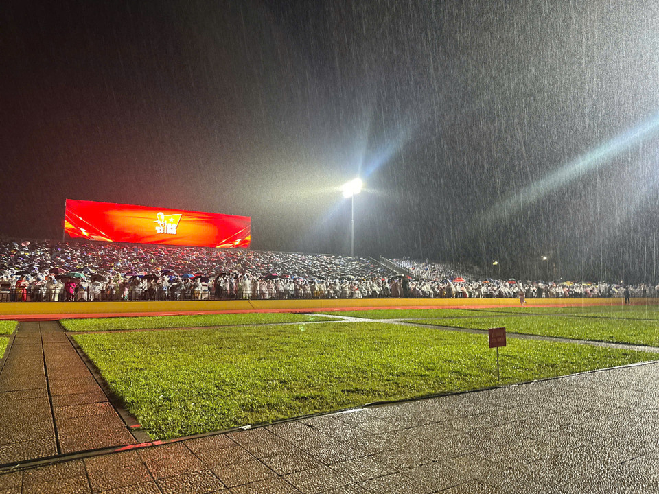 Người dân chờ đợi dưới mưa. (Ảnh: Thuỳ Giang/Vietnam+)