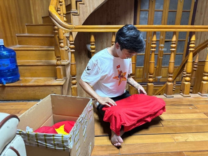 Hoàng Dũng gấp áo in hình cờ Tổ Quốc, chuẩn bị đóng gói gửi tặng học sinh trường Phổ thông dân tộc nội trú THPT Hà Giang, tỉnh Tuyên Quang, chiều 3/9. Ảnh: Nhân vật cung cấp