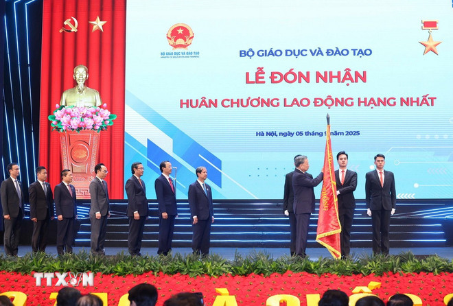Tổng Bí thư Tô Lâm gắn Huân chương Lao động hạng Nhất lên lá cờ truyền thống của Bộ Giáo dục-Đào tạo. (Ảnh: Thống Nhất/TTXVN) ttxvn-0509-tong-bi-thu-nganh-giao-duc-11.jpg