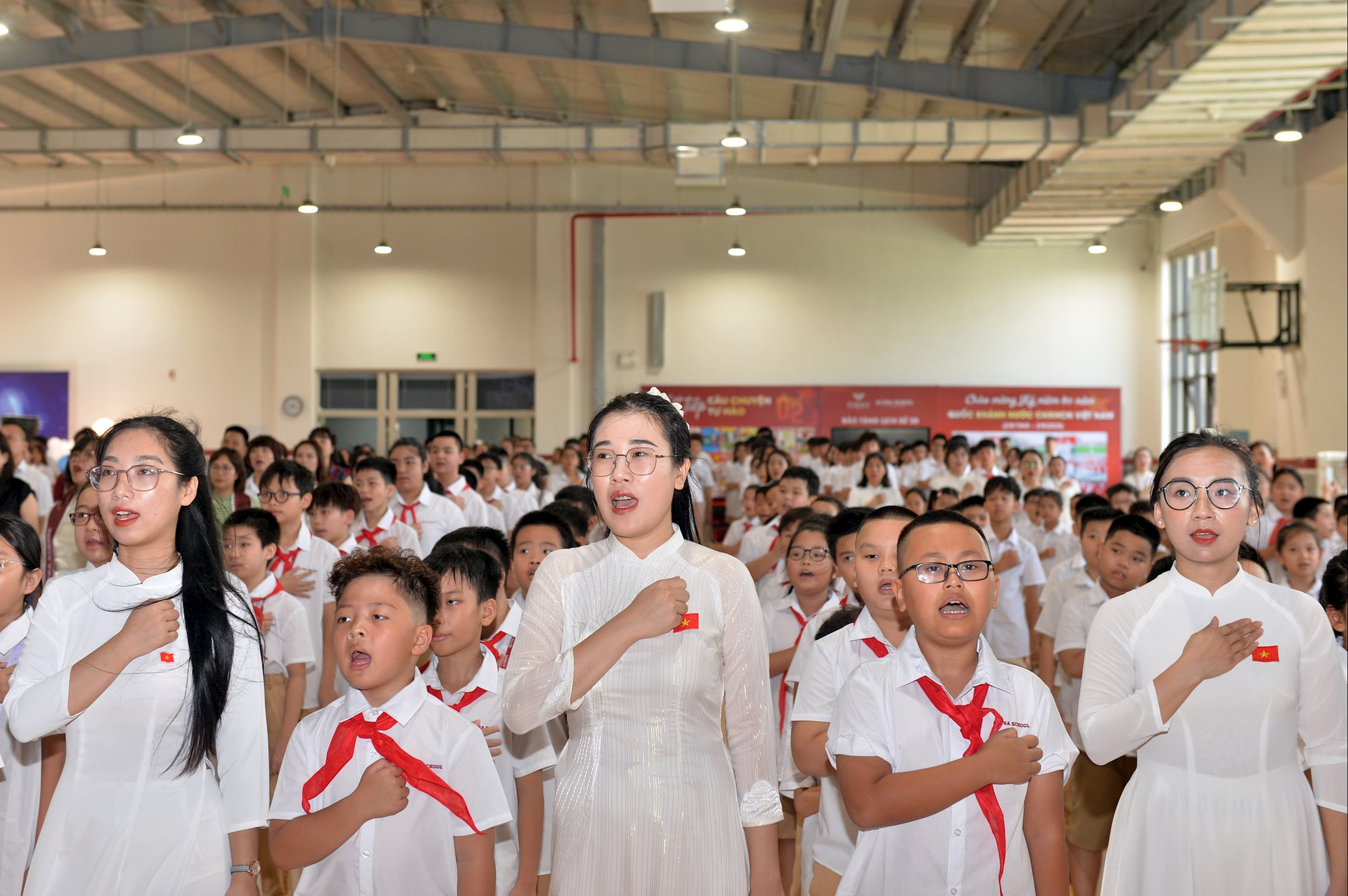 Thầy, cô giáo cùng học sinh trường Alpha, phường Hưng Đạo thực hiện nghi lễ chào cờ tại Lễ khai giảng năm học mới.
