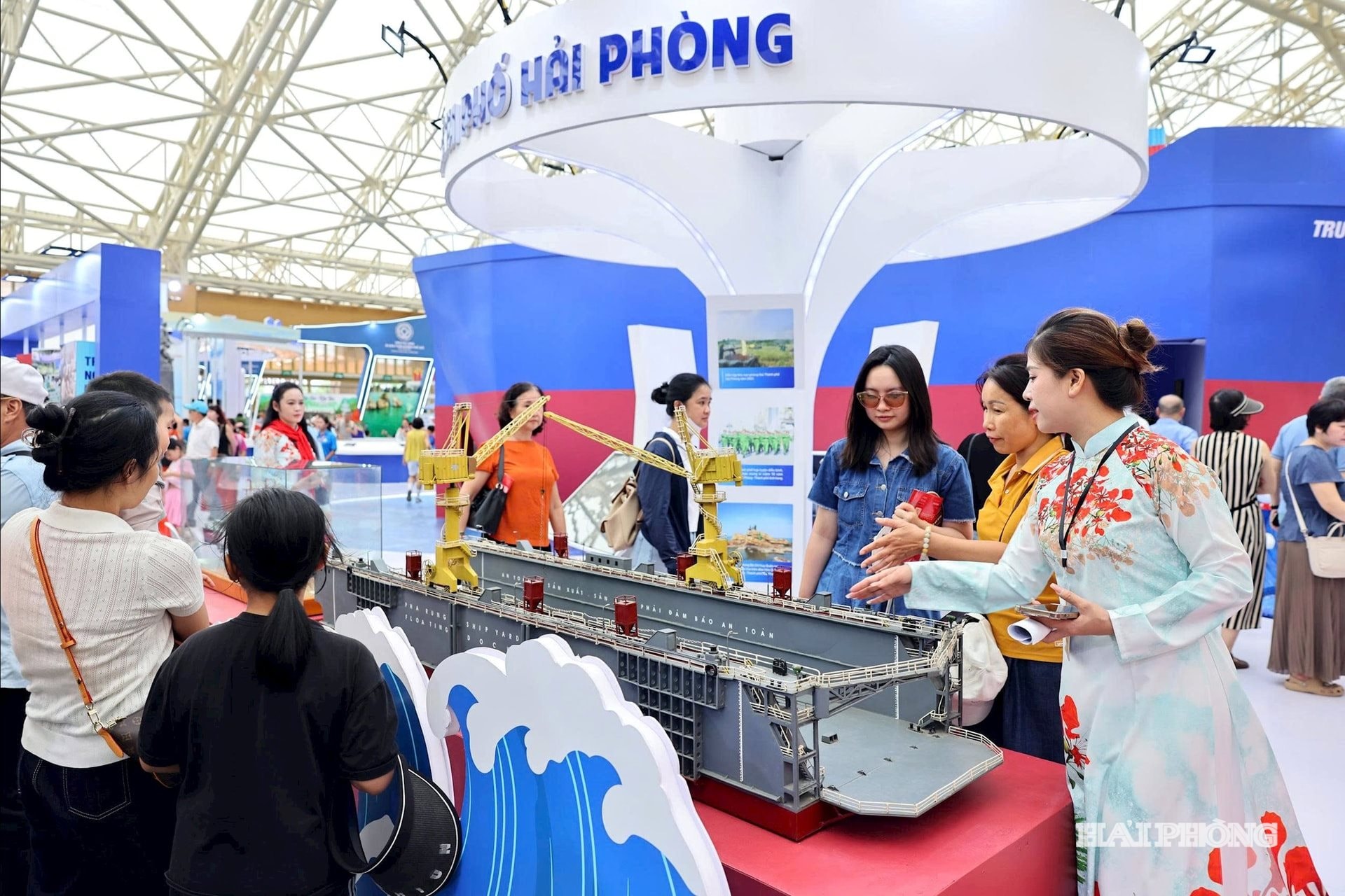 Hướng dẫn viên Hải Phượng giới thiệu với khách tham quan triển lãm về hệ thống Cảng biển tại khu vực trưng bày của thành phố Hải Phòng.