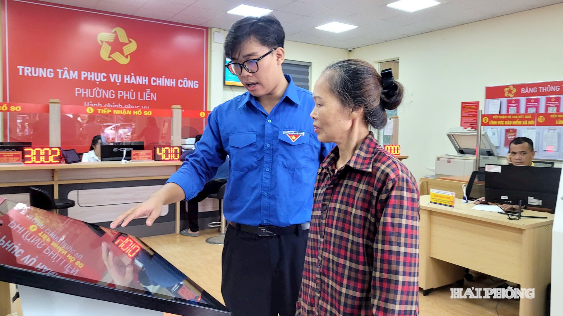 Đoàn viên thanh niên hướng dẫn người dân đến làm thủ tục hành chính tại Trung tâm Phục vụ hành chính công phường Phù Liễn.