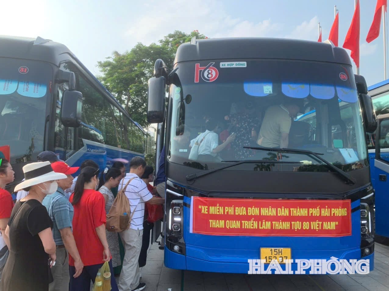 Crowds of people lined up to board free buses to visit the National Achievements Exhibition.